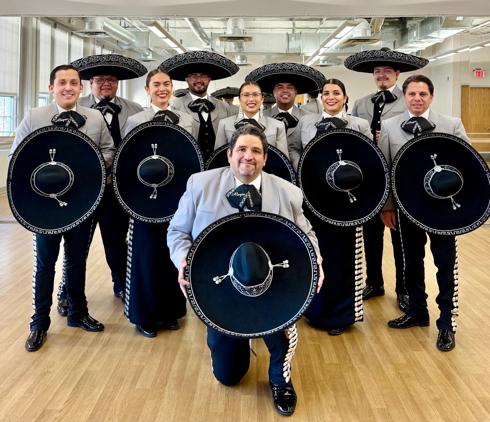 Mariachi Alegre ensemble holding sombreros in the studio